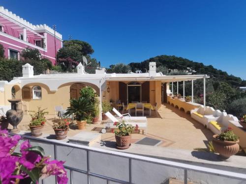 a house with a patio with potted plants on it at Sea view con terrazza e giardino 2 camere doppie 1 singola in Capri