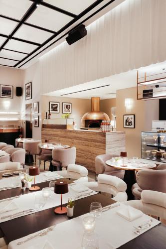 a restaurant with white chairs and tables and a counter at Lusso Hometels J One Business Bay in Dubai