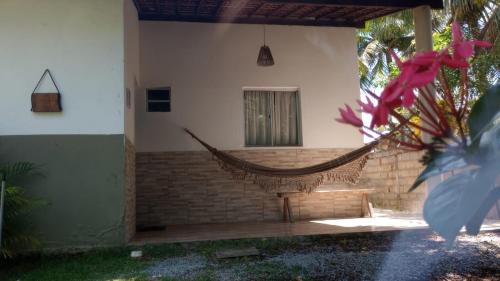 a hammock on the side of a house at Chalés Caminho do Mar in São Miguel dos Milagres