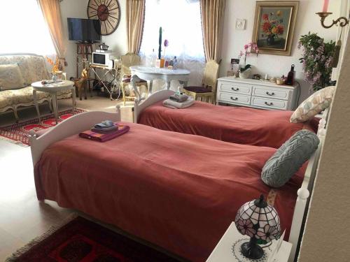 a bedroom with two beds and a living room at Double room in nice house near the forest (basement floor) in Brügg