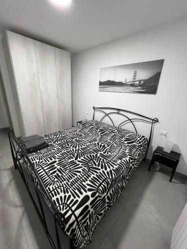 a bedroom with a bed with a black and white comforter at San Rocco 30 - camera in campagna - Piombino in Piombino