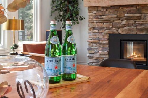two bottles of wine sitting on a wooden table at Modern/Rustic 2 Story Condo/3 Min Walk to Village in Blue Mountains