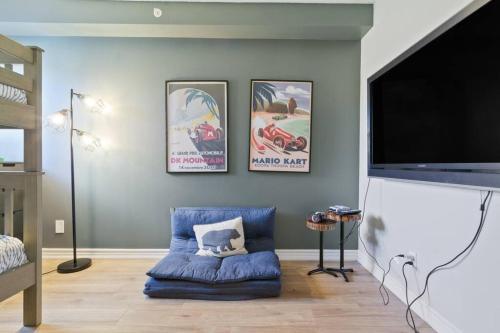 a living room with a blue couch and a flat screen tv at Modern/Rustic 2 Story Condo/3 Min Walk to Village in Blue Mountains