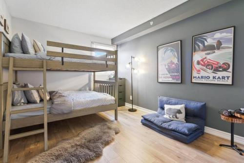 a bedroom with two bunk beds and a blue couch at Modern/Rustic 2 Story Condo/3 Min Walk to Village in Blue Mountains