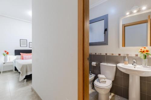a bathroom with a toilet and a sink and a bed at Fidalsa Enjoy Life in Guardamar del Segura