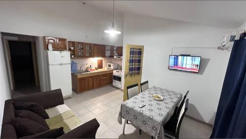 ein Wohnzimmer mit einem Tisch und einer Küche in der Unterkunft Cabaña El Silencio in Los Algarrobos