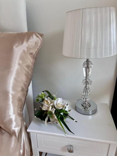 a table with a lamp and a bouquet of flowers on it at Vila na Spině in Vsetín