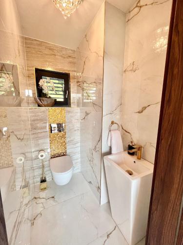 a white bathroom with a sink and a toilet at Vila na Spině in Vsetín