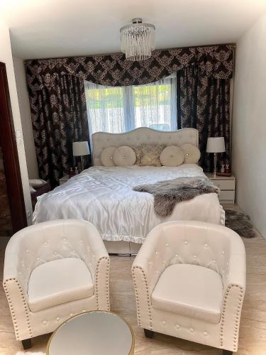 a bedroom with a bed and two chairs at Vila na Spině in Vsetín