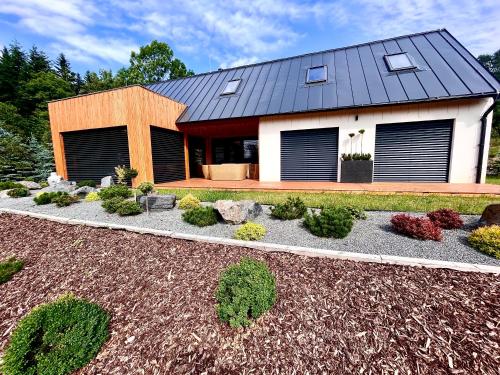 a house with a black roof and a garden at Vila na Spině in Vsetín