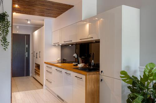 a kitchen with white cabinets and a wooden counter top at Apartament Sun Hill in Wisła