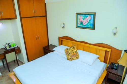 a bedroom with a bed with a pillow on it at Shangri-la Hotel Muyenga in Bugolobi