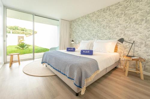 een slaapkamer met een bed en een groot raam bij Oceanside West in Ponta Delgada