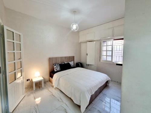 - une chambre blanche avec un lit et une fenêtre dans l'établissement Green Family House 3 Bedrooms with Garden View Casablanca, à Casablanca