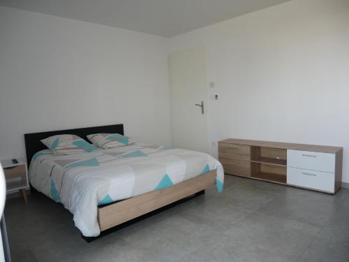 a bedroom with a bed and a wooden dresser at Studio lumineux avec terrasse in La Roche-sur-Yon