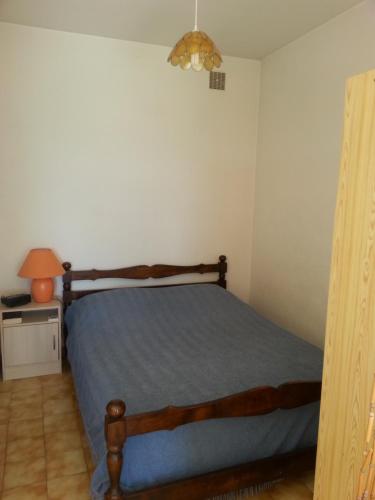 1 dormitorio con cama, lámpara y mesa en STUDIO indépendant au calme en Lumio