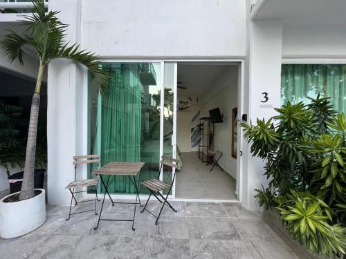 une terrasse avec une table, des chaises et des plantes dans l'établissement Residencial Gran Palma, à Acapulco