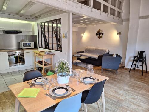 une salle à manger avec une table et une cuisine dans l'établissement La Porte de la Dombes - centre ville - 50m2 - classé 3 étoiles, à Montluel