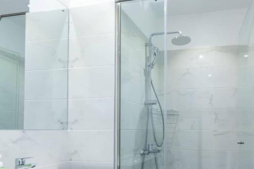 a shower with a glass door in a bathroom at Lennox Beautiful 2 Bed in Accra