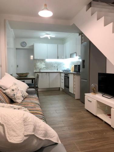 a living room with a couch and a kitchen at A Casinha Gomes in Nisa