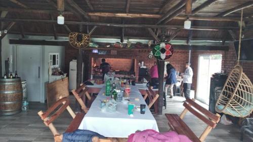 uma mesa longa numa sala com pessoas à sua volta em Casa quinta em General Rodríguez