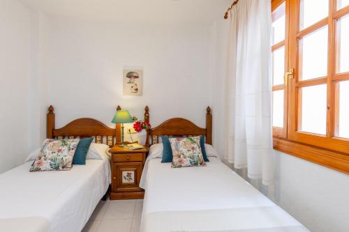 2 Betten in einem Zimmer mit 2 Fenstern in der Unterkunft Fidalsa Feel the Sea in El Moncayo