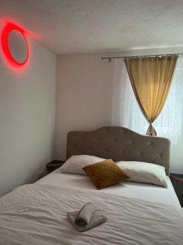 1 dormitorio con 1 cama con luz roja. en S-E-N, en Bosanski Novi