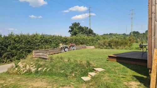 a garden with a table and a bike in a field at Orlická přehrada Chata Malá in Kožlí u Orlíka