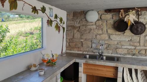 een keuken met een wastafel en een stenen muur bij La casa di Vic in Levice