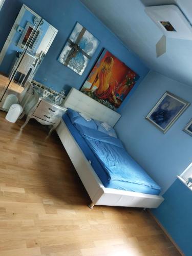 a room with a blue wall with a bed in it at Queen house apartman in Zagreb