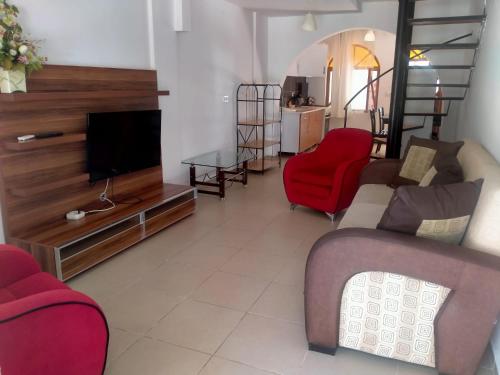 a living room with a couch and a tv at Sincer Otel in Kusadası