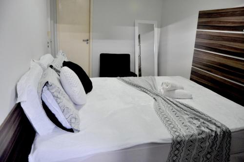 ein Schlafzimmer mit einem weißen Bett mit weißer Bettwäsche und Kissen in der Unterkunft Super Duplex Beira Mar na melhor praia de Maceió-NEO 709 in Maceió