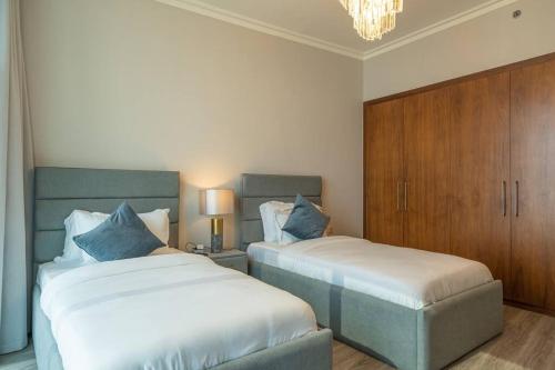 a hotel room with two beds and a chandelier at Stylish 3BR with Balcony Burj Khalifa & Fountain Views Near Dubai Mall in Dubai