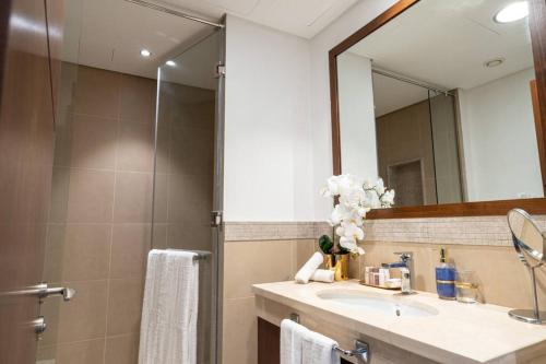 a bathroom with a sink and a mirror at Stylish 3BR with Balcony Burj Khalifa & Fountain Views Near Dubai Mall in Dubai