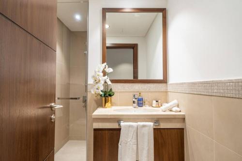 een badkamer met een wastafel en een spiegel bij WORLD CLASS 3BR with full BURJ KHALIFA and FOUNTAIN VIEW in Dubai