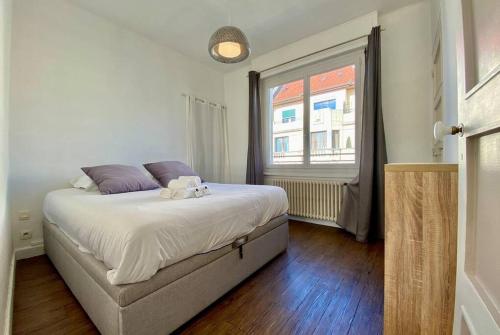 um quarto com uma cama grande e uma janela em Toit-terrasse traversant plein centre 100m du lac em Annecy