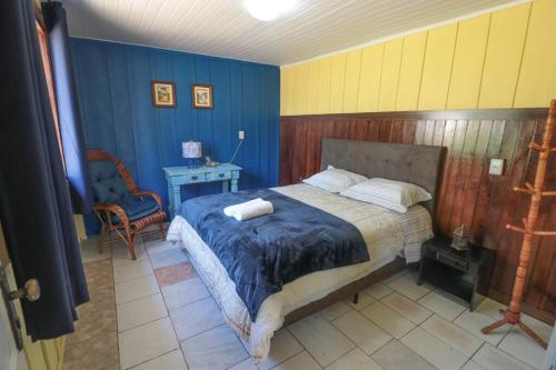 a bedroom with a bed and a table and a chair at Chácara do Sapé in São José dos Pinhais