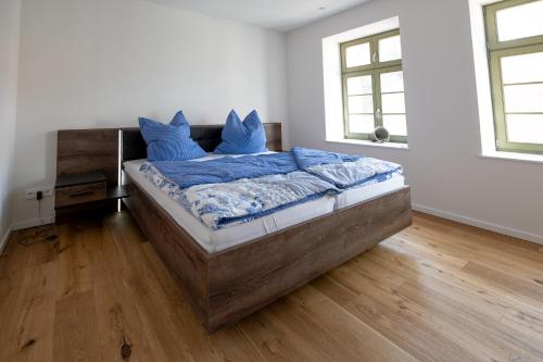 a bedroom with a bed with blue pillows on it at Ferienwohnungen - barrierefrei - im sanierten Gutshof in Lalendorf