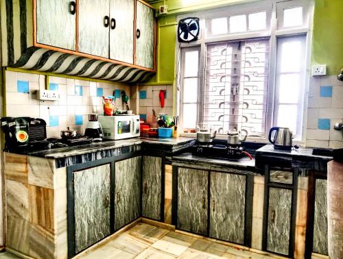 cocina con armarios de madera y encimera en Hidden Monkey Hostels en Darjeeling