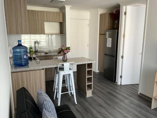 a small kitchen with a counter and a refrigerator at Departamento Lynch Iquique in Iquique