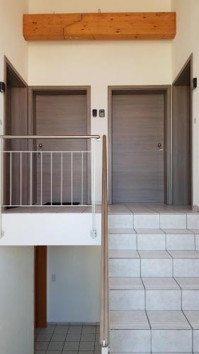 two garage doors on a house with a staircase at Gasthaus Löwen in Dettighofen