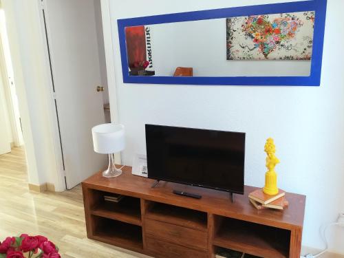 a flat screen tv sitting on top of a wooden table at El Coqueto de Vallecas in Madrid