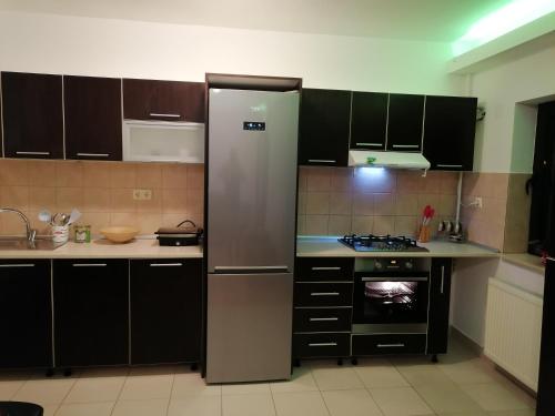 een keuken met een roestvrijstalen koelkast en een fornuis bij Home Residence in Piatra Neamţ