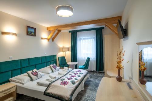 een slaapkamer met een bed en een tafel en stoelen bij Willa Monte Rosa in Zakopane