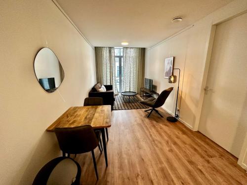 - un salon avec une table et un miroir dans l'établissement Charming 1 bedroom serviced apartment 57m2, à Rotterdam