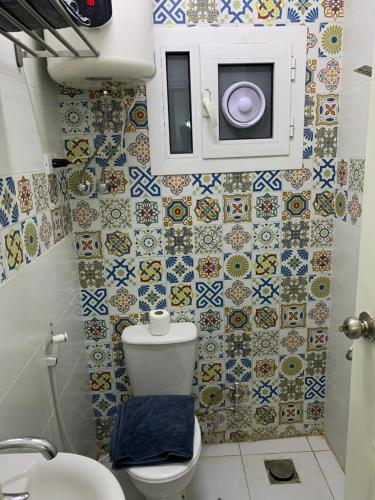 a small bathroom with a toilet and tiles on the wall at Z Pyramids Inn in Cairo