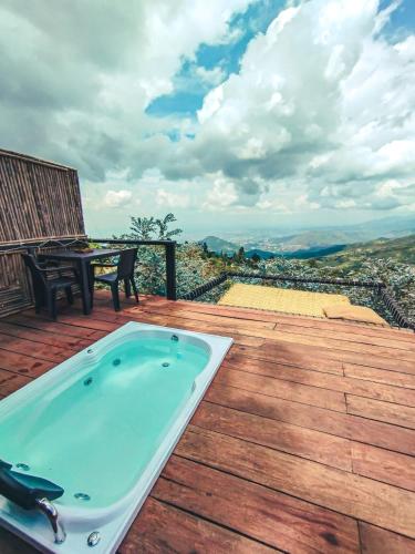 a hot tub on a wooden deck with a table at Romero Glamping y Cabañas in Cali