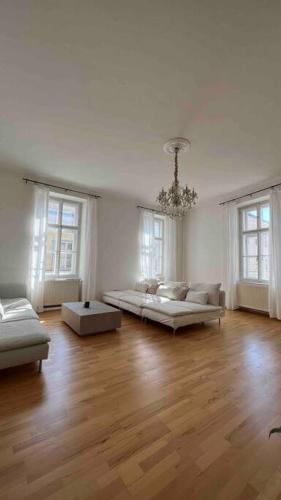 uma grande sala de estar com duas camas e janelas em Altbauwohnung im Univiertel! em Graz