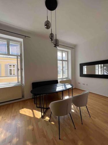 a living room with a table and chairs in it at Altbauwohnung im Univiertel! in Graz