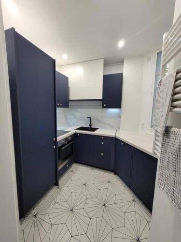 - une cuisine avec des placards bleus et un évier dans l'établissement La Villa - Charmant logement proche Paris, à Saint-Mandé
